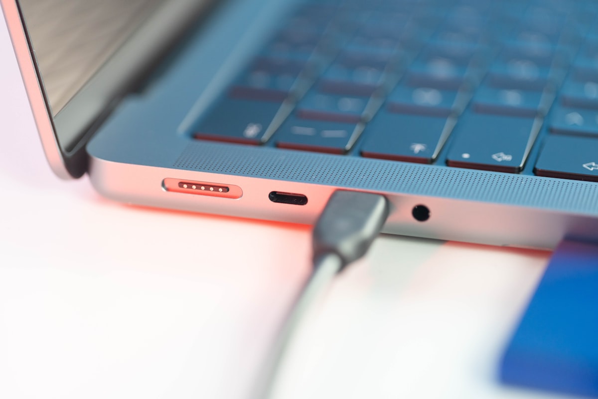 Close-up of a laptop with a charger plugged in