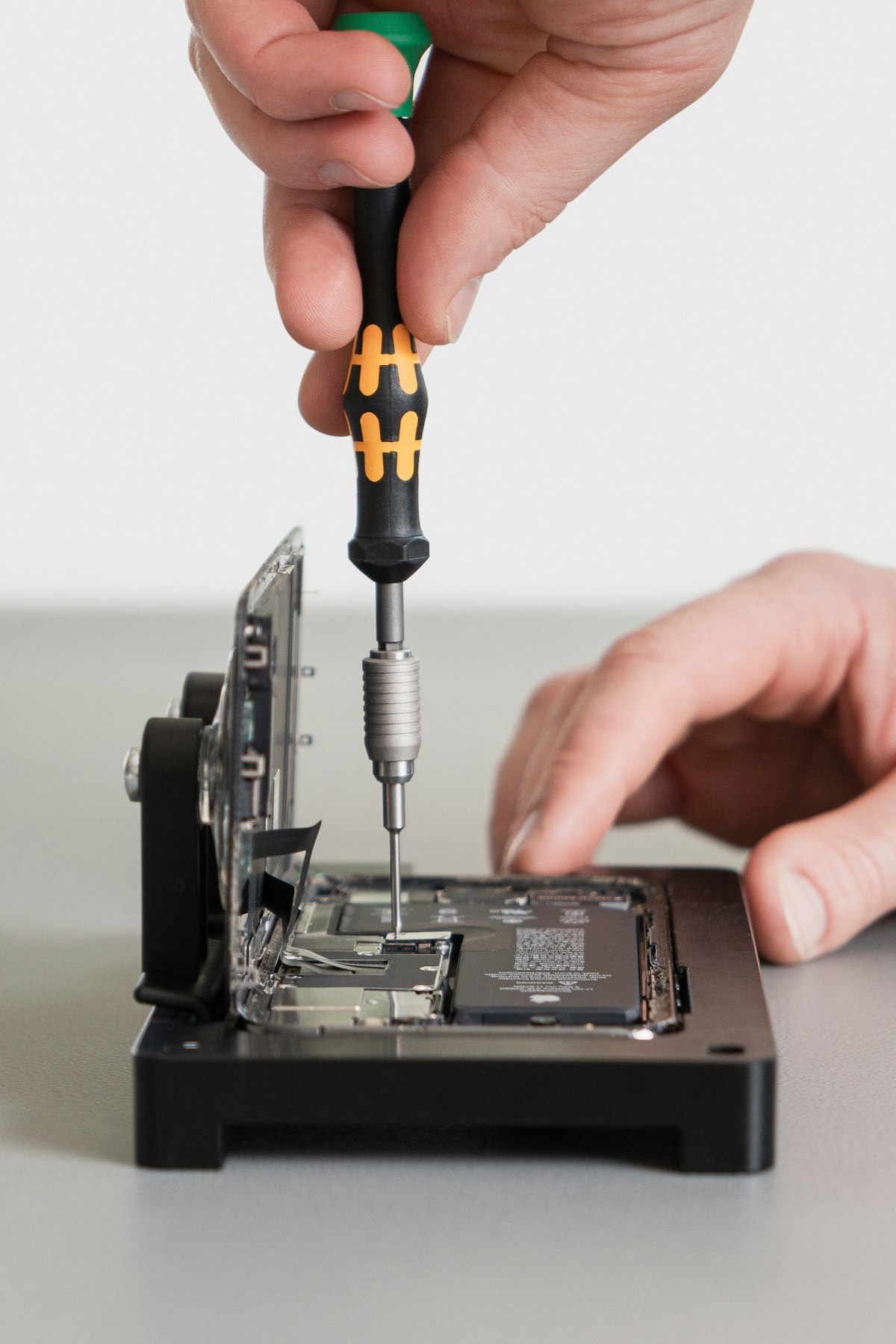 A person using a screwdriver to repair an electronic device