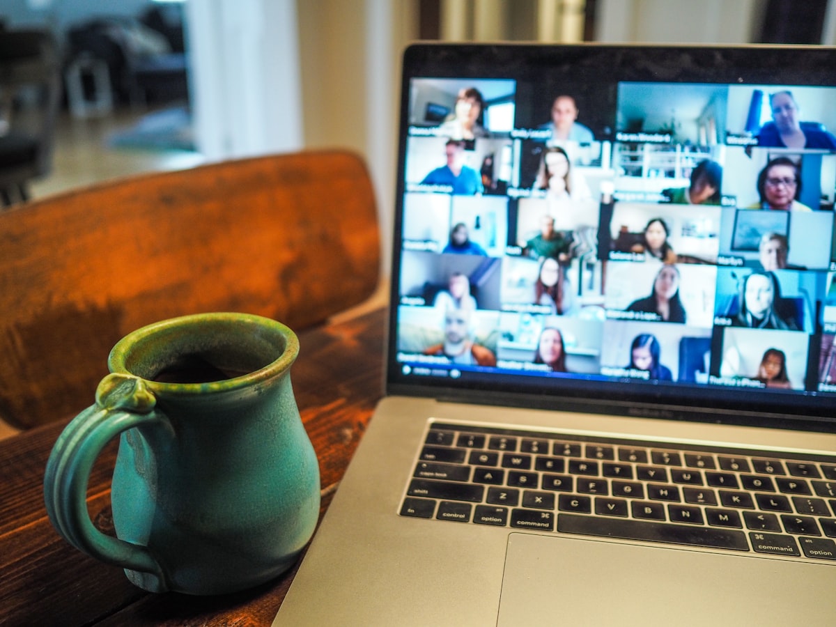 A laptop displaying a video call with a group of people